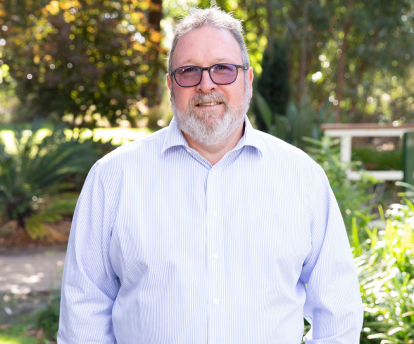 Jamie Kelly, Bendigo Principal Jamie stands with his hands in his pockets, wearing a long sleeve shirt and dark coloured glasses